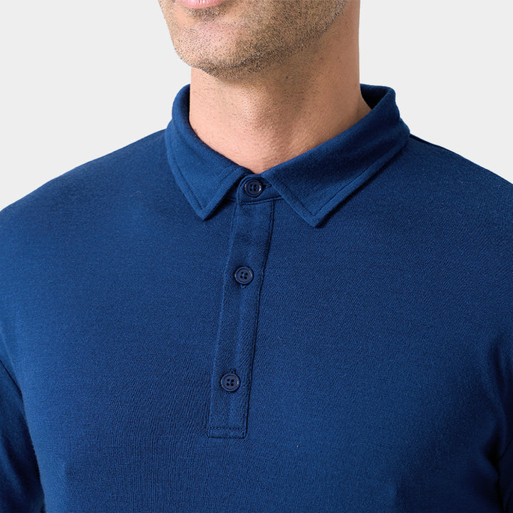 Male model wearing white merino wool polo shirt, featuring flexible fit, short sleeves, three-button placket, and stand-up collar for sun protection.
