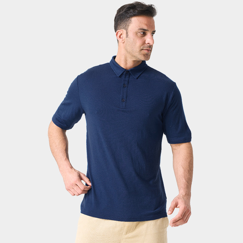 Male model wearing white merino wool polo shirt, featuring flexible fit, short sleeves, three-button placket, and stand-up collar for sun protection.
