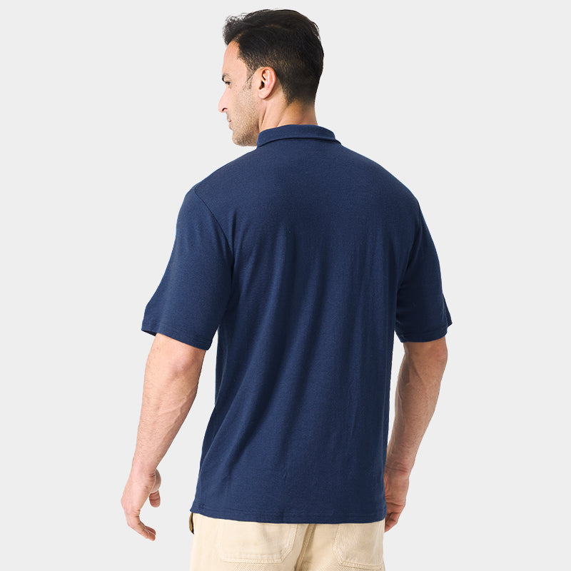 Male model wearing white merino wool polo shirt, featuring flexible fit, short sleeves, three-button placket, and stand-up collar for sun protection.
