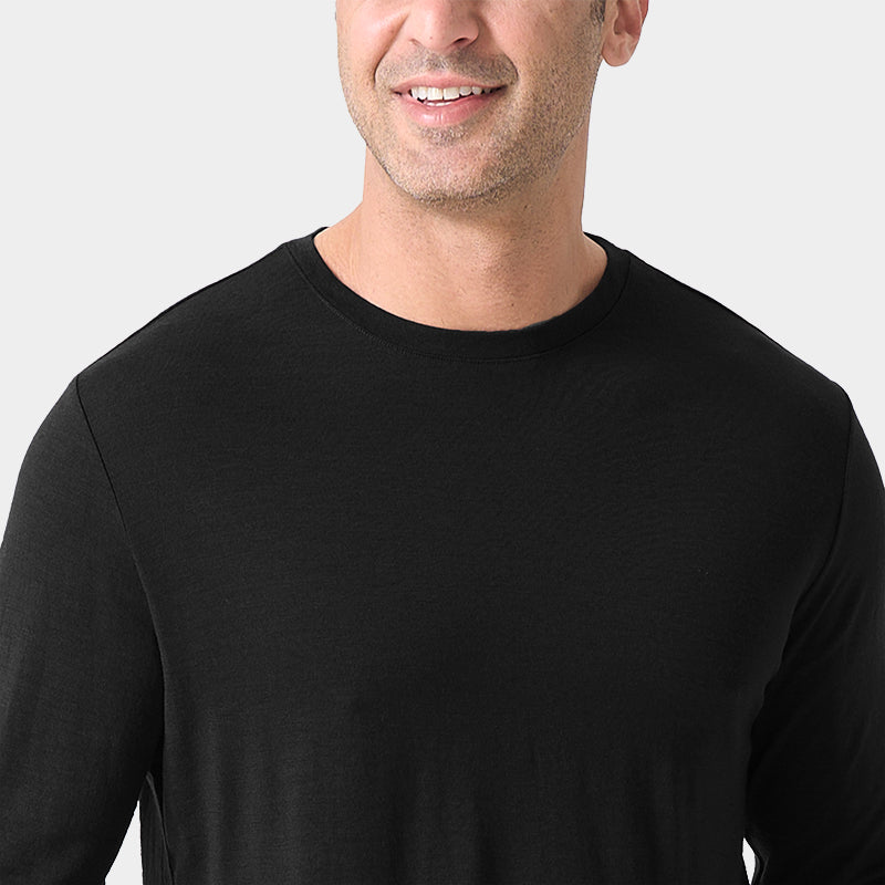 Male model wearing a lightweight Merino wool long sleeve crew base layer top, breathable and comfortable, shown in black.