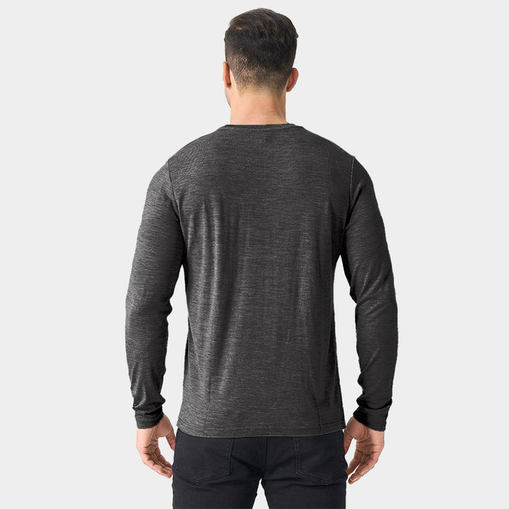 Male model wearing a lightweight Merino wool long sleeve crew base layer top, breathable and comfortable, shown in dark grey heather.