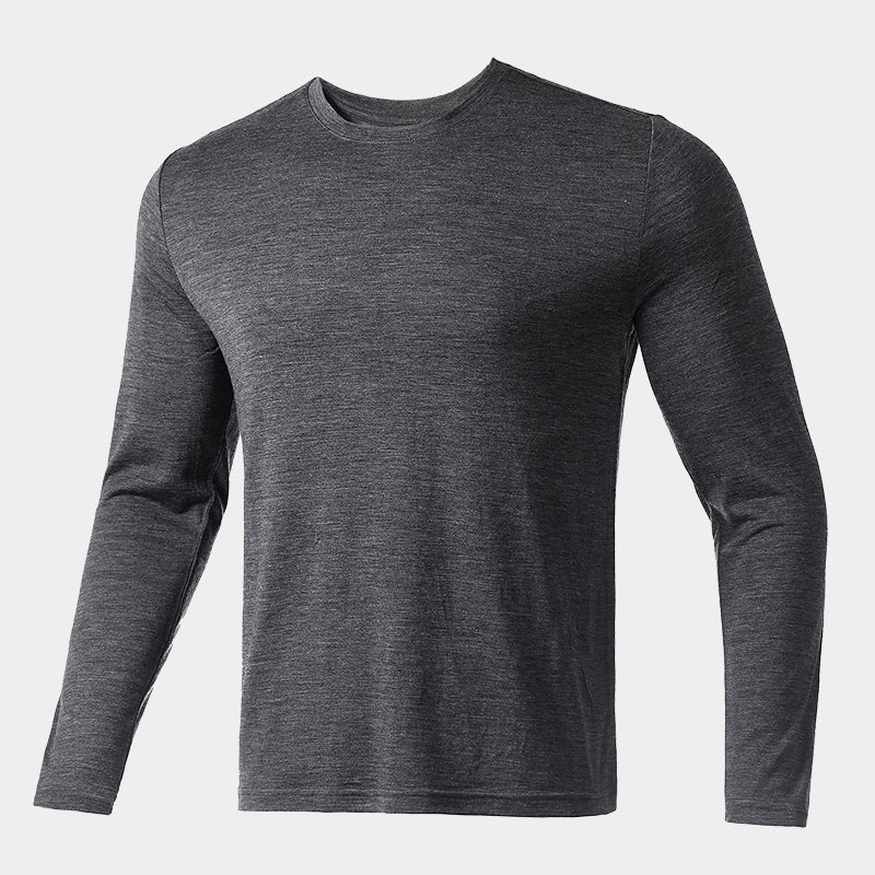 Male model wearing a lightweight Merino wool long sleeve crew base layer top, breathable and comfortable, shown in dark grey heather.