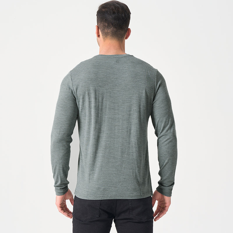 Male model wearing a lightweight Merino wool long sleeve crew base layer top, breathable and comfortable, shown in grey heather.