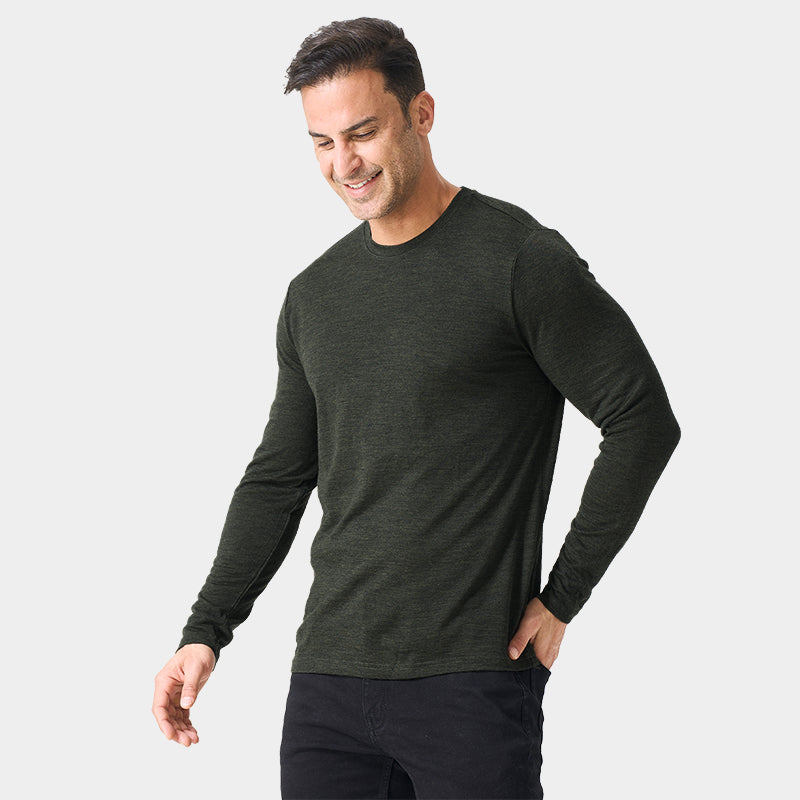 Male model wearing a lightweight Merino wool long sleeve crew base layer top, breathable and comfortable, shown in moss green heather.