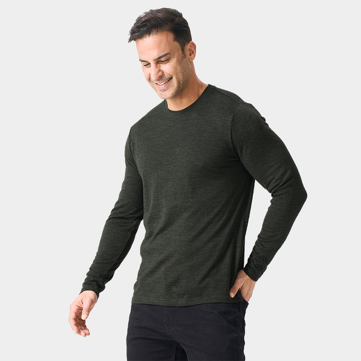 Male model wearing a lightweight Merino wool long sleeve crew base layer top, breathable and comfortable, shown in moss green heather.