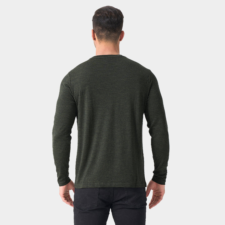 Male model wearing a lightweight Merino wool long sleeve crew base layer top, breathable and comfortable, shown in moss green heather.