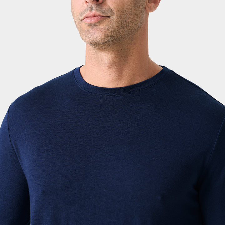 Male model wearing a lightweight Merino wool long sleeve crew base layer top, breathable and comfortable, shown in navy.