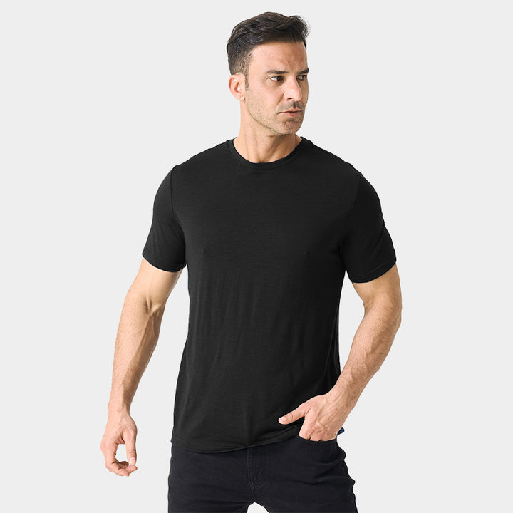 Male model wearing a lightweight Merino wool short sleeve crew t-shirt, breathable and moisture-wicking, shown in Black.