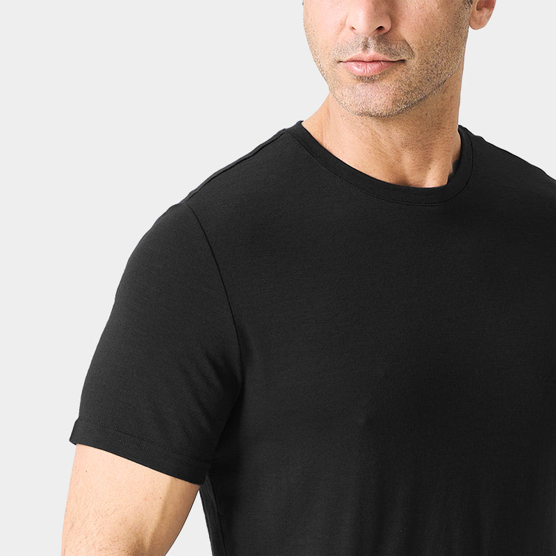 Male model wearing a lightweight Merino wool short sleeve crew t-shirt, breathable and moisture-wicking, shown in Black.