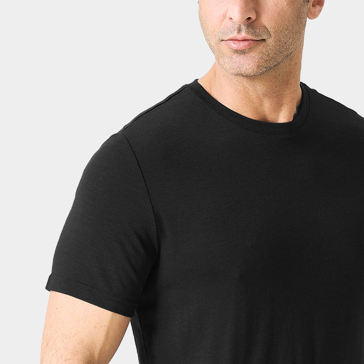 Male model wearing a lightweight Merino wool short sleeve crew t-shirt, breathable and moisture-wicking, shown in Black.