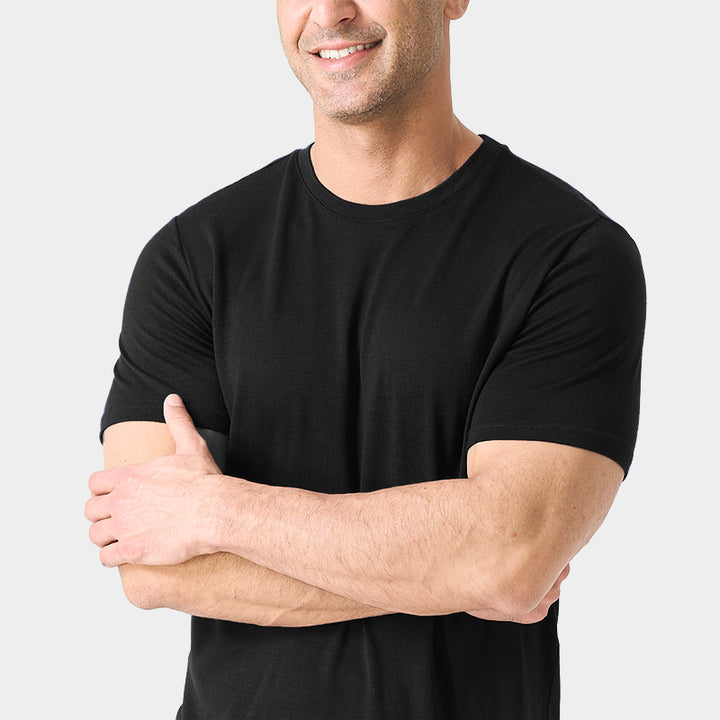 Male model wearing a lightweight Merino wool short sleeve crew t-shirt, breathable and moisture-wicking, shown in Black.