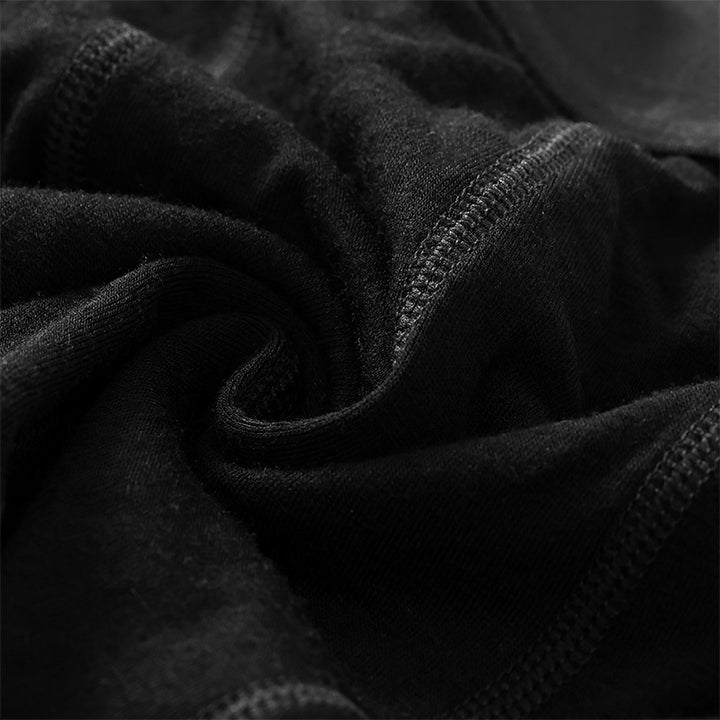 Male model wearing a lightweight Merino wool short sleeve crew t-shirt, breathable and moisture-wicking, shown in Black.