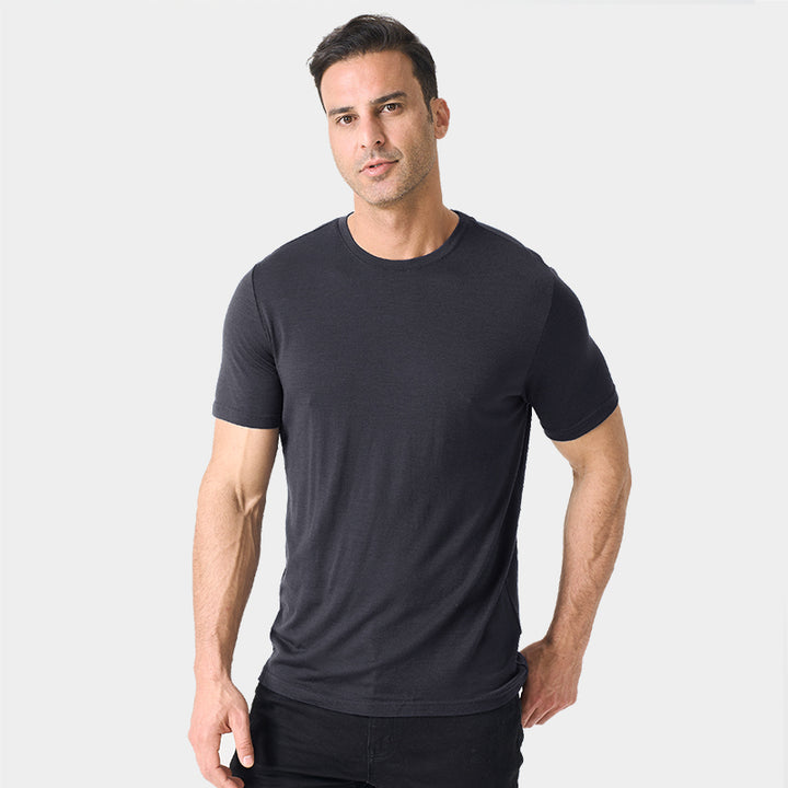 Male model wearing a lightweight Merino wool short sleeve crew t-shirt, breathable and moisture-wicking, shown in charcoal.