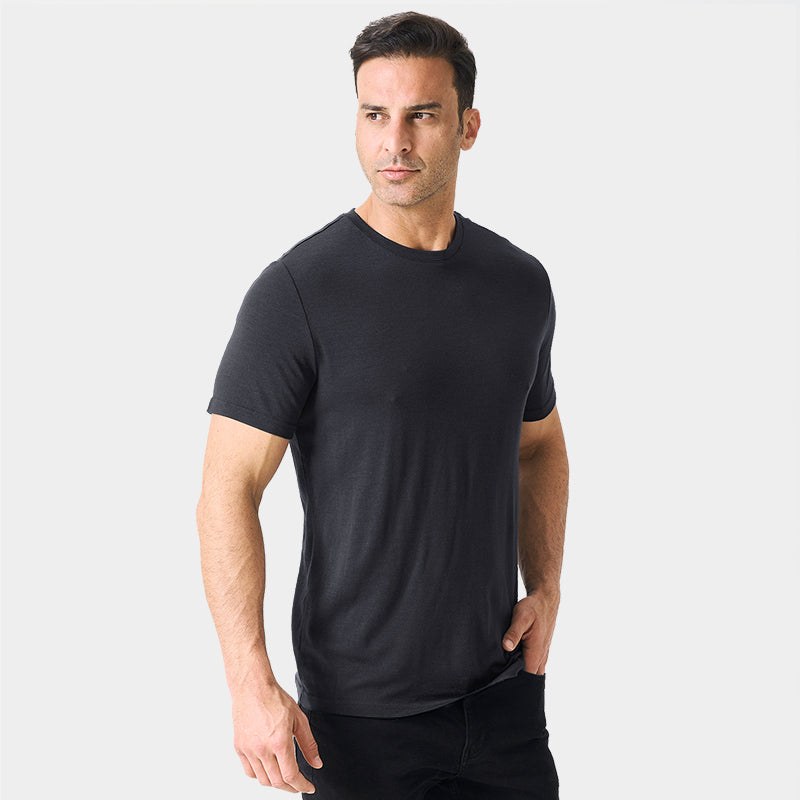 Male model wearing a lightweight Merino wool short sleeve crew t-shirt, breathable and moisture-wicking, shown in charcoal.