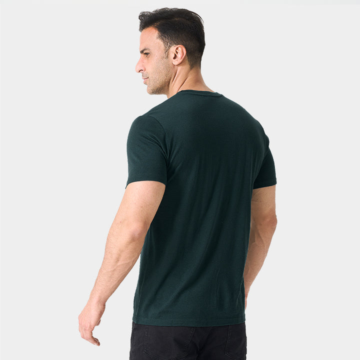 Male model wearing a lightweight Merino wool short sleeve crew t-shirt, breathable and moisture-wicking, shown in dark green.