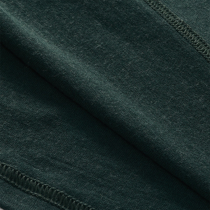 Male model wearing a lightweight Merino wool short sleeve crew t-shirt, breathable and moisture-wicking, shown in dark green.