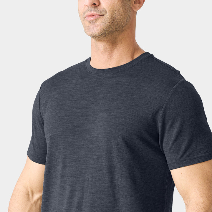 Male model wearing a lightweight Merino wool short sleeve crew t-shirt, breathable and moisture-wicking, shown in dark grey.