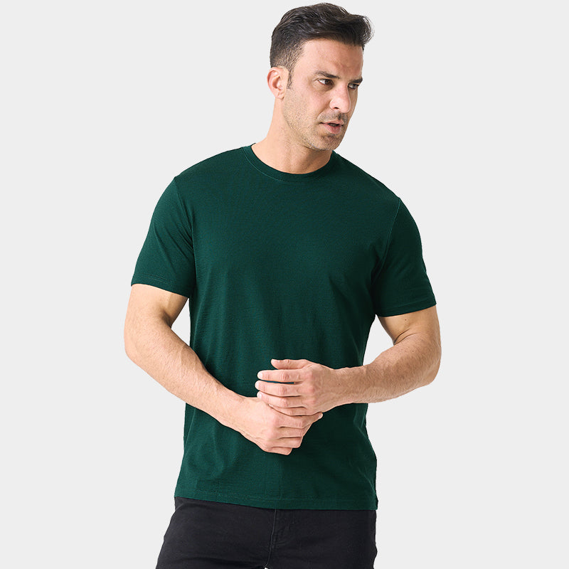 Male model wearing a lightweight Merino wool short sleeve crew t-shirt, breathable and moisture-wicking, shown in forest green.