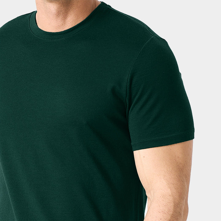 Male model wearing a lightweight Merino wool short sleeve crew t-shirt, breathable and moisture-wicking, shown in forest green.