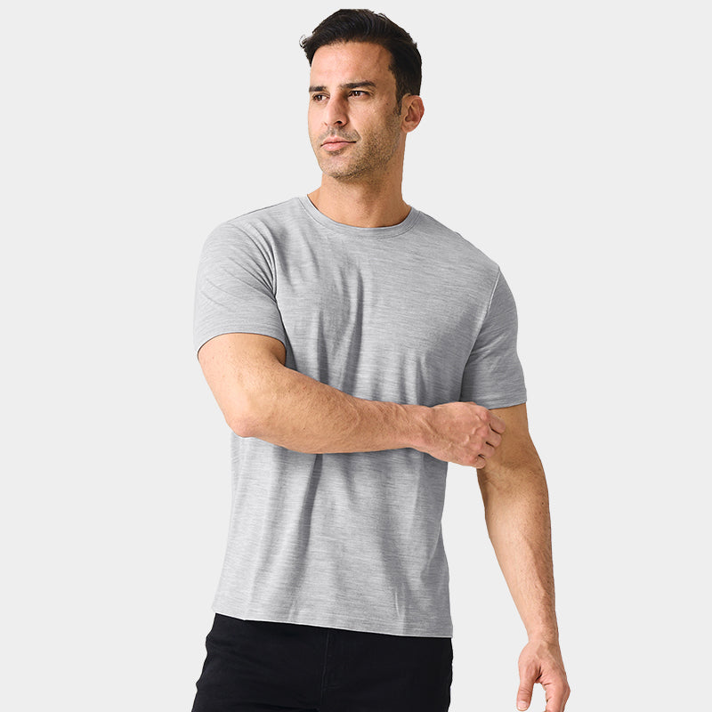 Male model wearing a lightweight Merino wool short sleeve crew t-shirt, breathable and moisture-wicking, shown in light grey.
