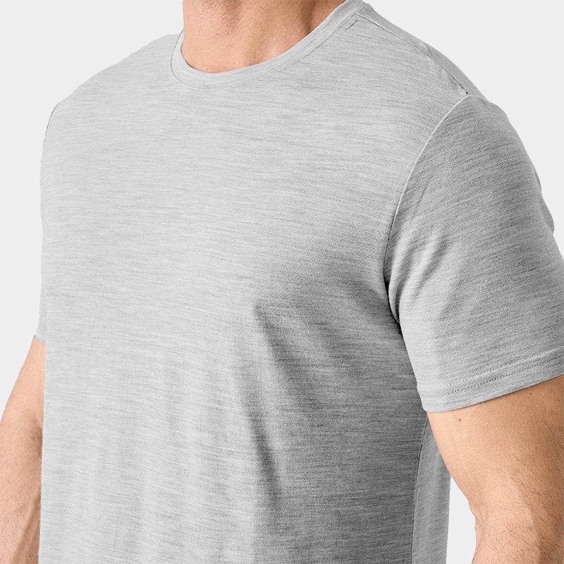 Male model wearing a lightweight Merino wool short sleeve crew t-shirt, breathable and moisture-wicking, shown in light grey.