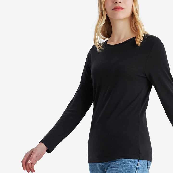 Famel model wearing a lightweight Merino wool long sleeve crew base layer top, breathable and comfortable, shown in black.