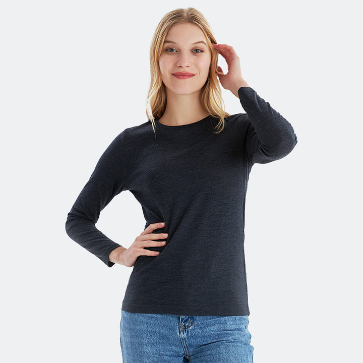 Famel model wearing a lightweight Merino wool long sleeve crew base layer top, breathable and comfortable, shown in black heather.