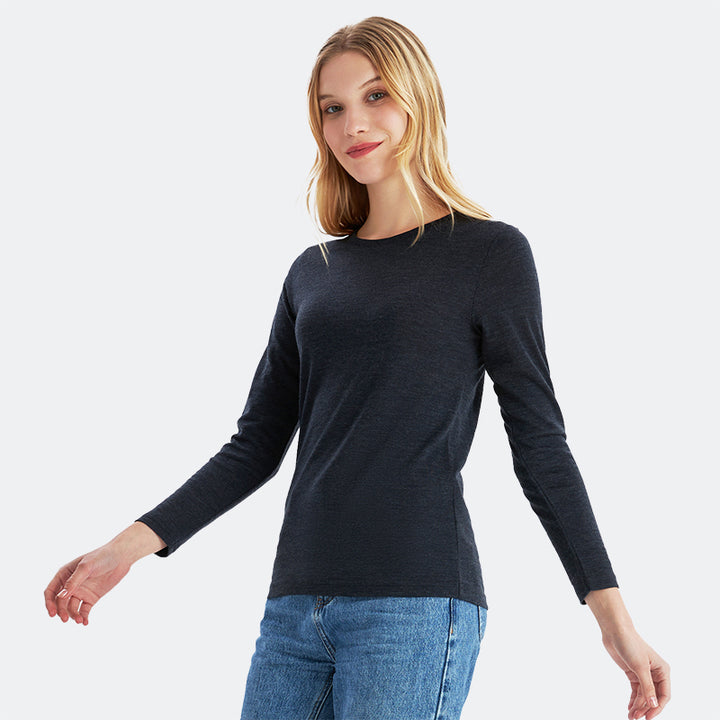 Famel model wearing a lightweight Merino wool long sleeve crew base layer top, breathable and comfortable, shown in black heather.