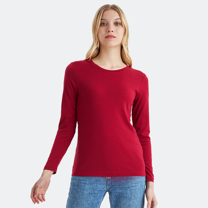 Famel model wearing a lightweight Merino wool long sleeve crew base layer top, breathable and comfortable, shown in crimson red heather.