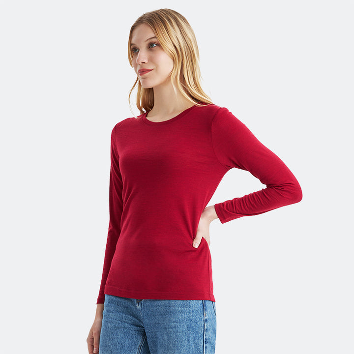 Famel model wearing a lightweight Merino wool long sleeve crew base layer top, breathable and comfortable, shown in crimson red heather.