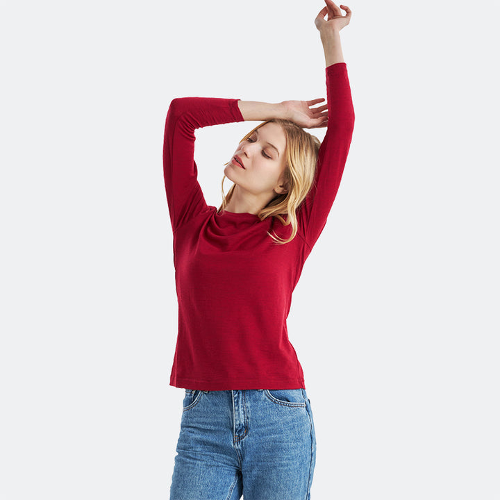 Famel model wearing a lightweight Merino wool long sleeve crew base layer top, breathable and comfortable, shown in crimson red heather.