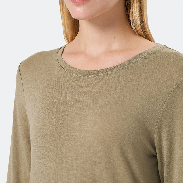 Famel model wearing a lightweight Merino wool long sleeve crew base layer top, breathable and comfortable, shown in dark olive.