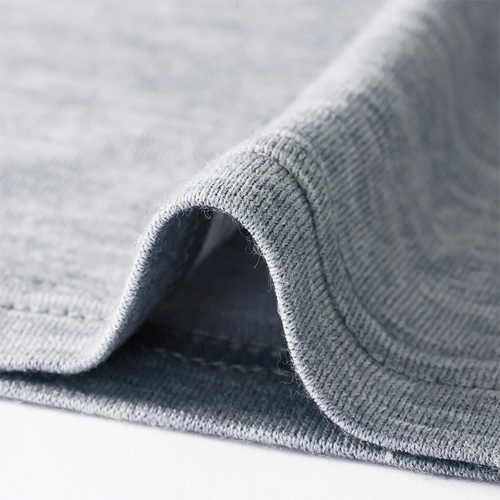 Famel model wearing a lightweight Merino wool long sleeve crew base layer top, breathable and comfortable, shown in grey heather.