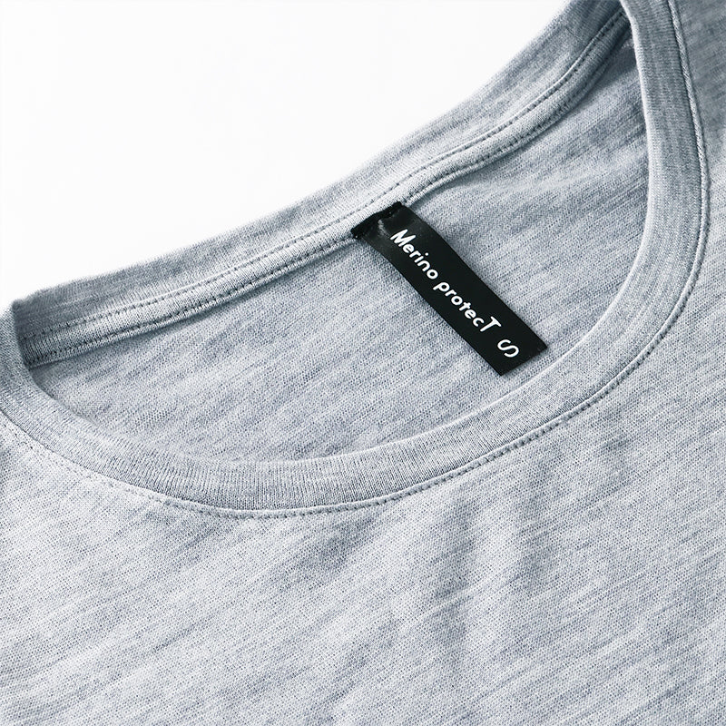 Famel model wearing a lightweight Merino wool long sleeve crew base layer top, breathable and comfortable, shown in grey heather.