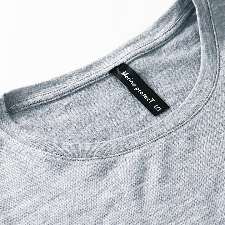Famel model wearing a lightweight Merino wool long sleeve crew base layer top, breathable and comfortable, shown in grey heather.