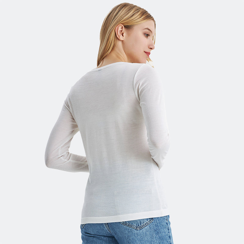 Famel model wearing a lightweight Merino wool long sleeve crew base layer top, breathable and comfortable, shown in natural cream.