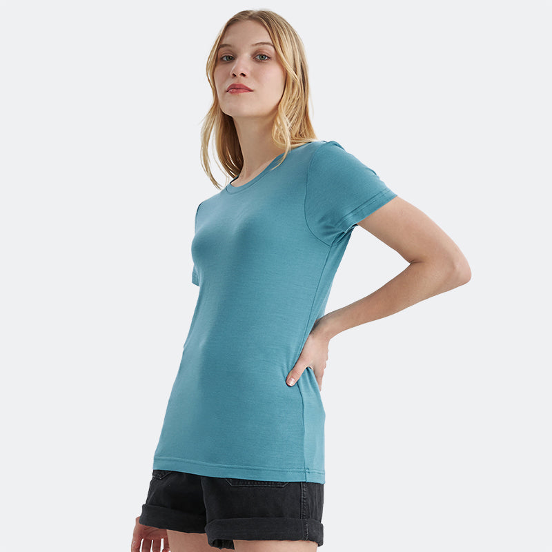 Famel model wearing a lightweight Merino wool short sleeve crew t-shirt, breathable and comfortable, shown in teal.