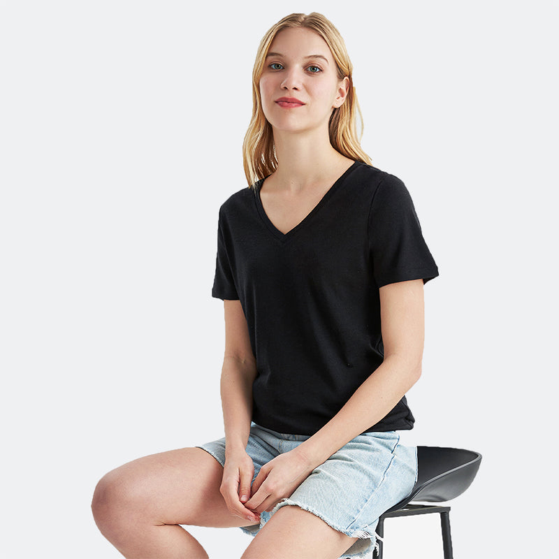 Famel model wearing a lightweight Merino wool short sleeve v-neck t-shirt, breathable and comfortable, shown in Black.