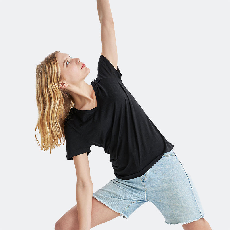 Famel model wearing a lightweight Merino wool short sleeve v-neck t-shirt, breathable and comfortable, shown in Black.