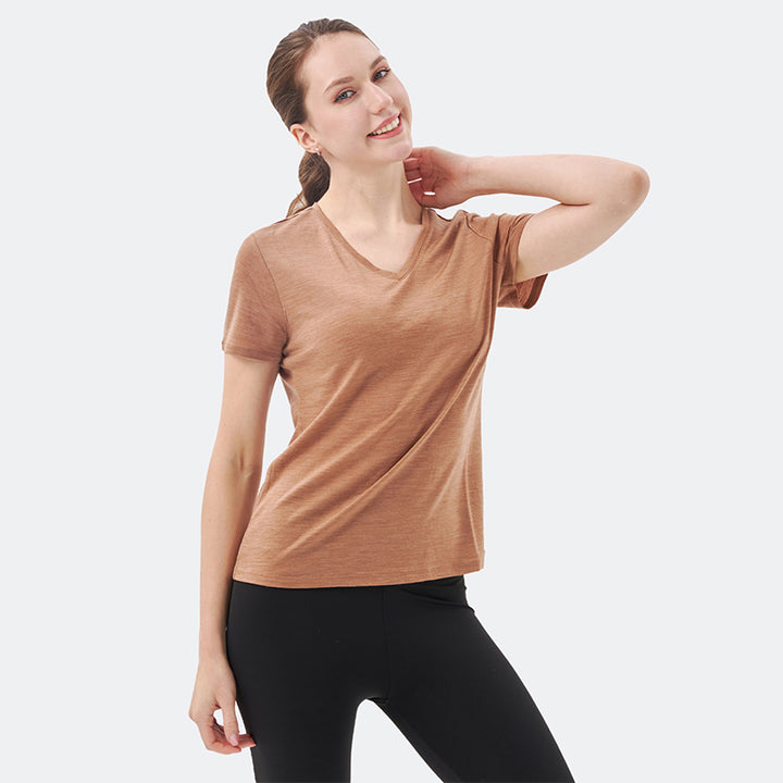 Famel model wearing a lightweight Merino wool short sleeve v-neck t-shirt, breathable and comfortable, shown in Caramel.