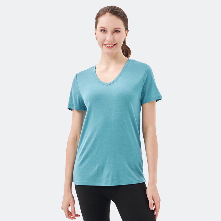 Famel model wearing a lightweight Merino wool short sleeve v-neck t-shirt, breathable and comfortable, shown in teal.
