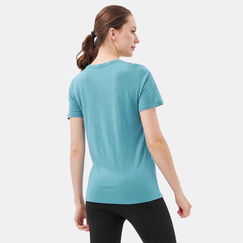 Famel model wearing a lightweight Merino wool short sleeve v-neck t-shirt, breathable and comfortable, shown in teal.