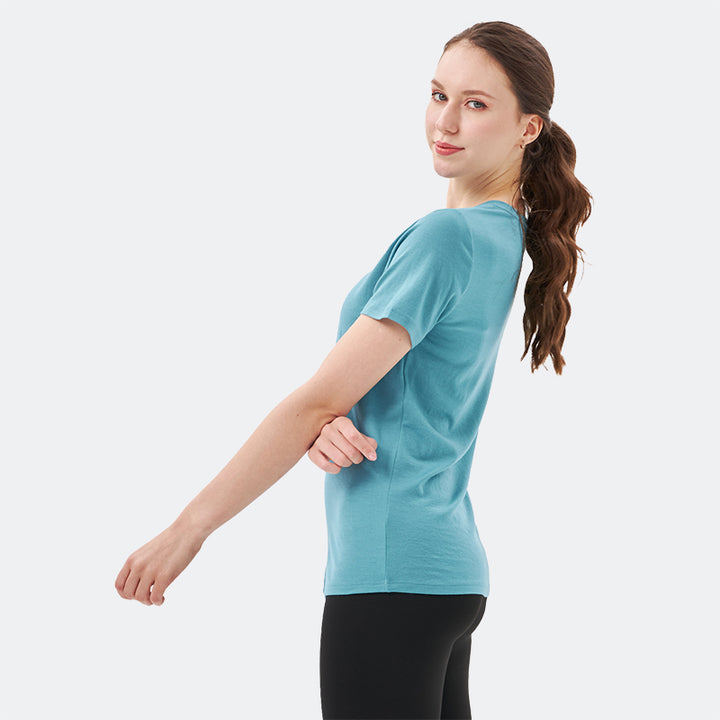 Famel model wearing a lightweight Merino wool short sleeve v-neck t-shirt, breathable and comfortable, shown in teal.