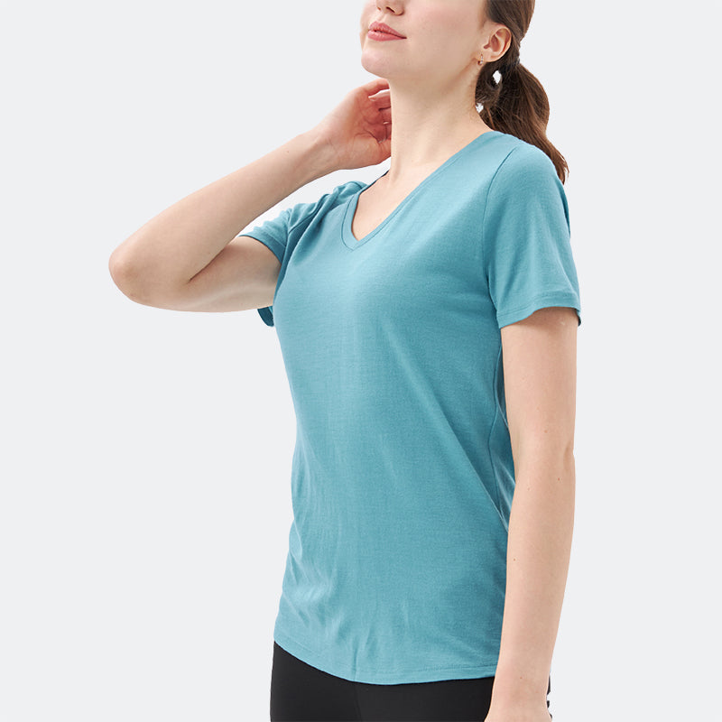 Famel model wearing a lightweight Merino wool short sleeve v-neck t-shirt, breathable and comfortable, shown in teal.
